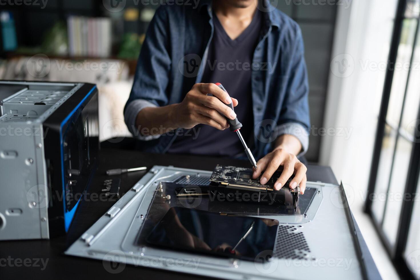 a engineer working on a computer with a screwdriver photo