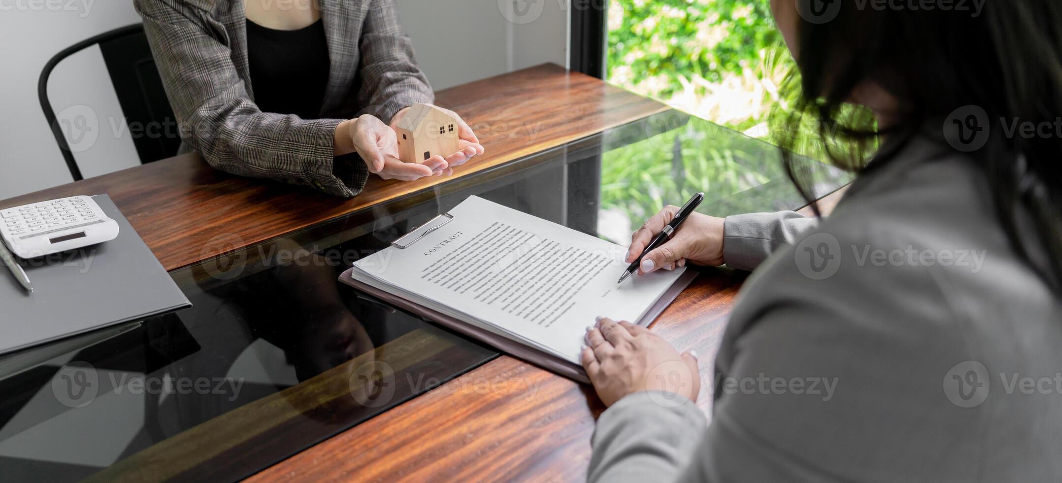 a woman signing a contract with another woman photo