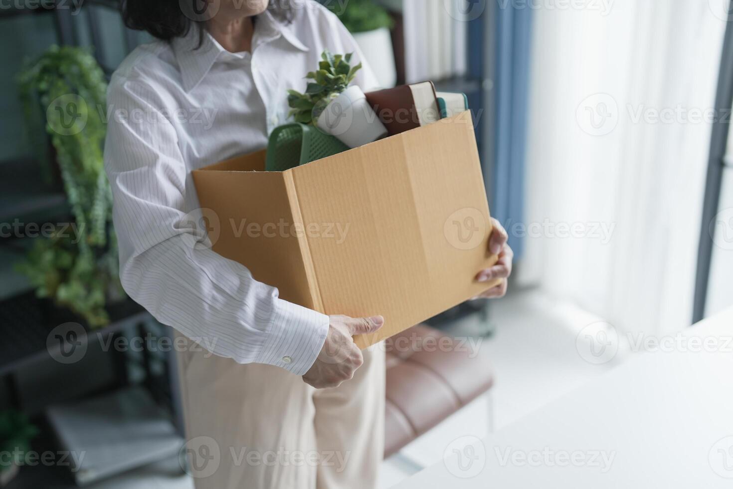 senior asian business woman sending resignation letter and packing Stuff Resign Depress or carrying business cardboard box in office layoff retired from company. photo