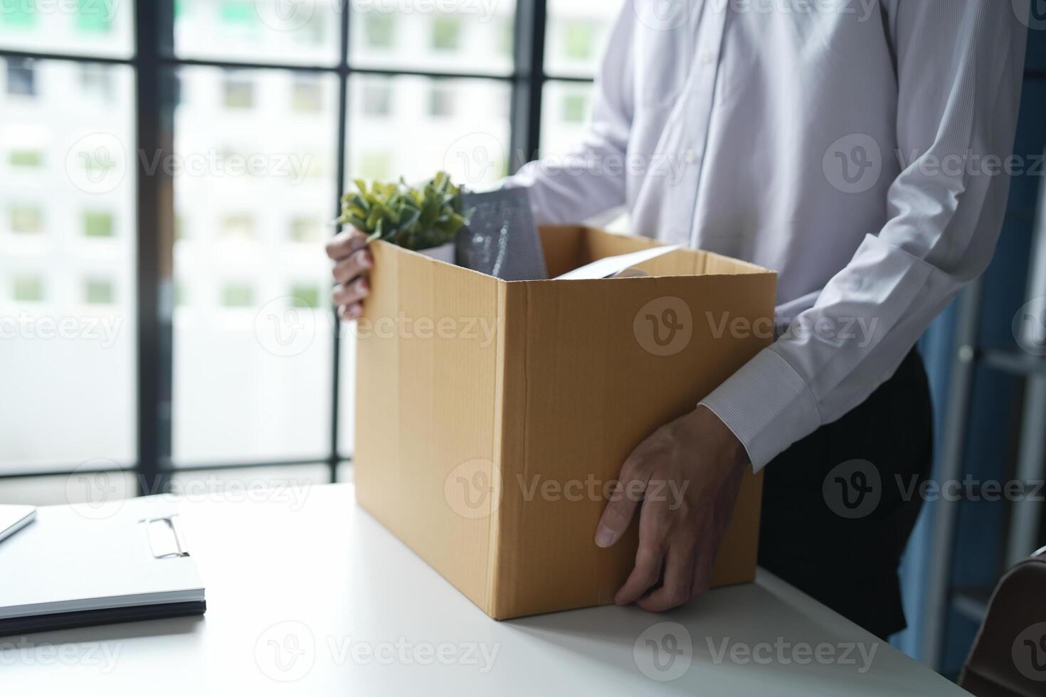 Businessman sending resignation letter and packing Stuff Resign Depress or carrying business cardboard box Change of job from company resign photo