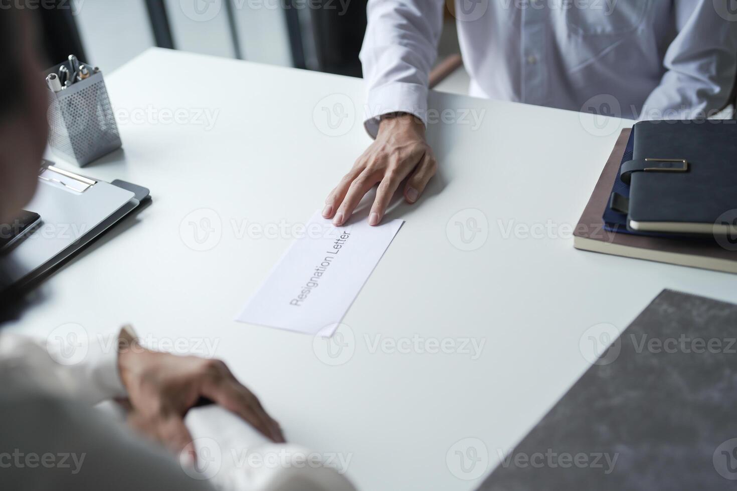 Business man sending resignation letter to boss and Holding Stuff Resign Depress or carrying cardboard box by desk photo