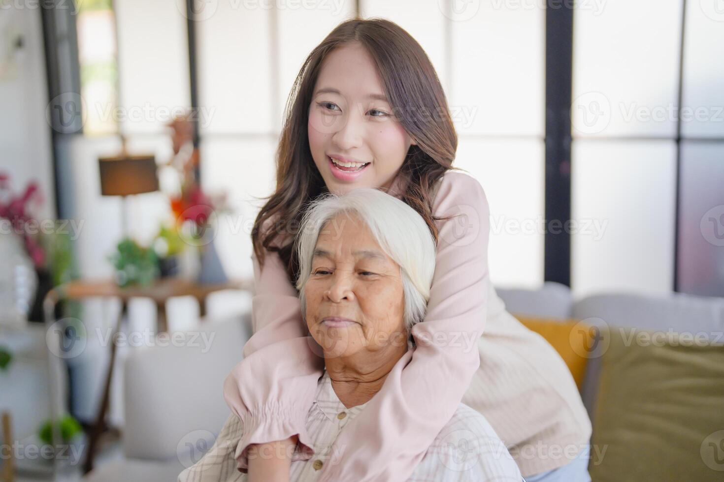asian woman with elderly woman in living room. photo