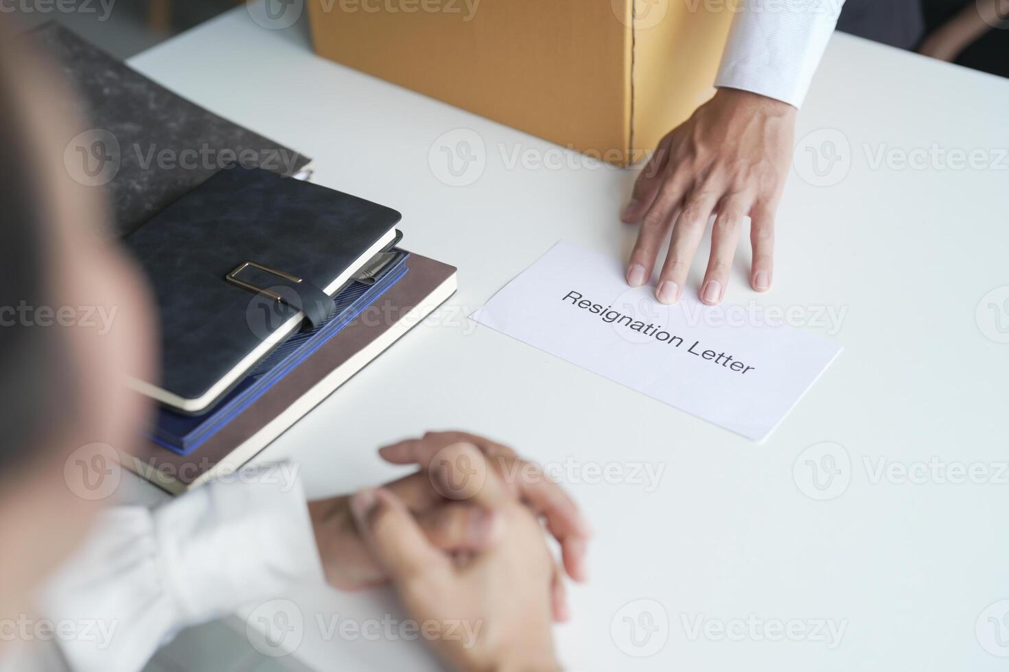 Business man sending resignation letter to boss and Holding Stuff Resign Depress or carrying cardboard box by desk in office photo