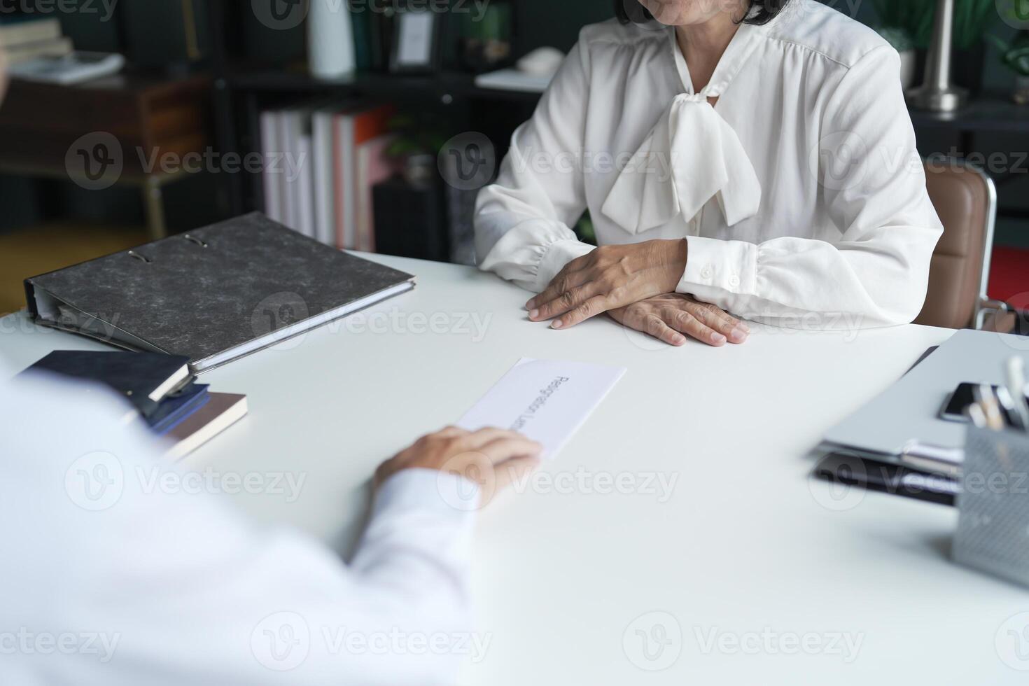 Businessman sending resignation letter to boss and Holding Stuff Resign Depress or carrying cardboard box by desk in office. photo