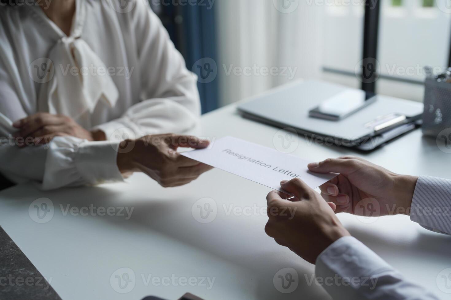 Business man sending resignation letter to boss and Holding Stuff Depress or carrying cardboard box by desk in office photo