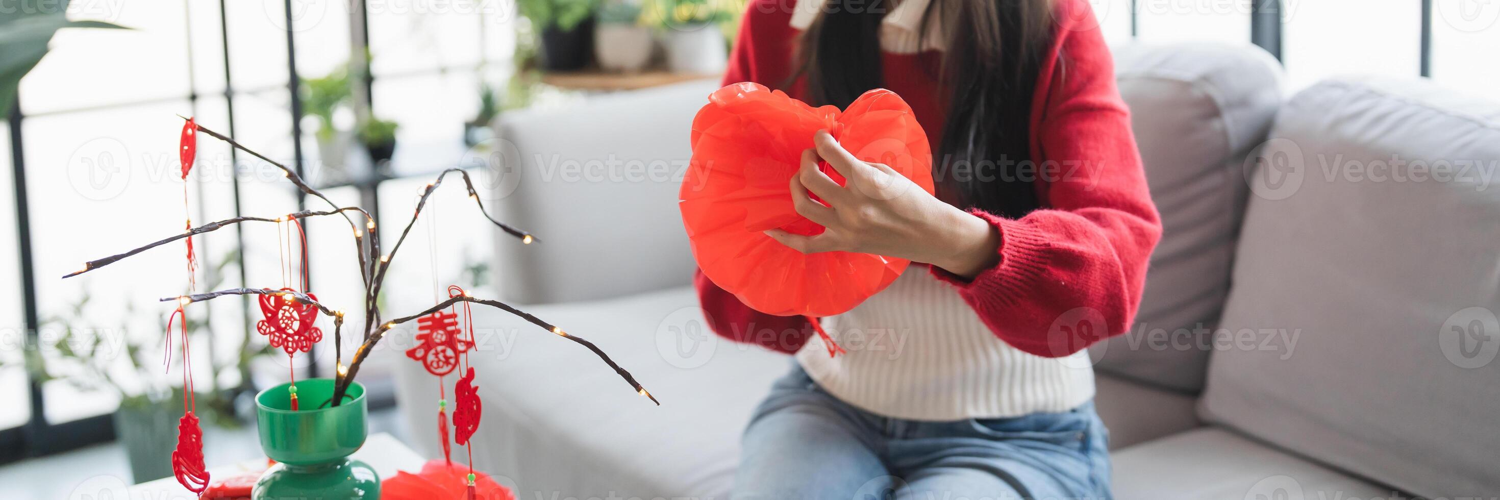 a woman sitting on a couch holding a red paper flower photo