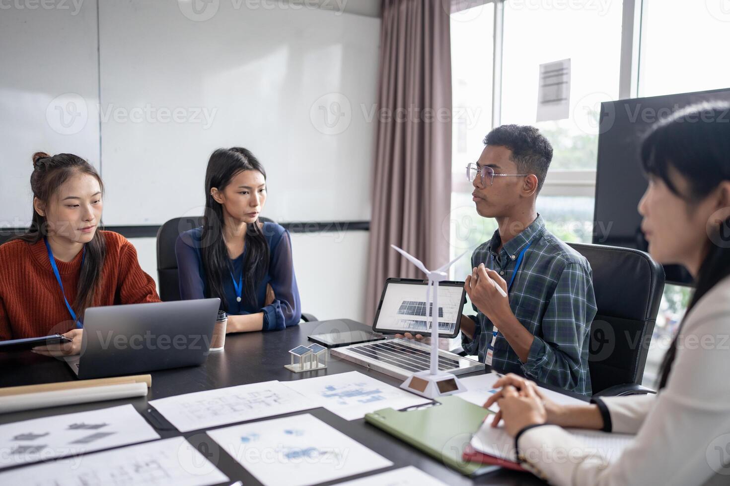 a group of business people sitting around a table with laptops photo