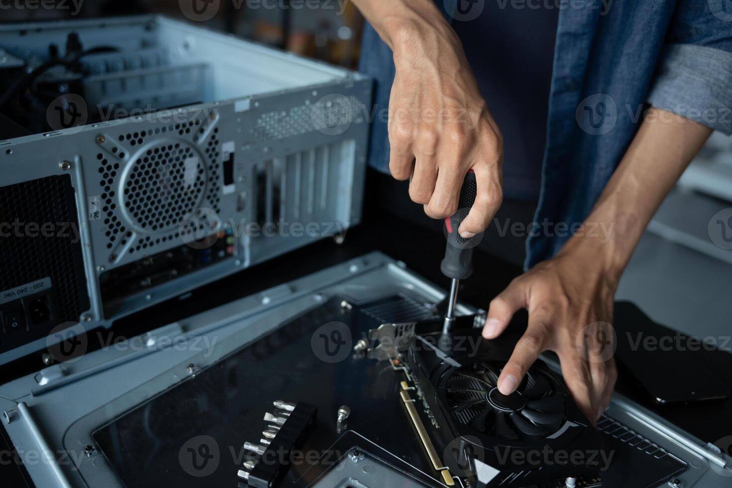 a person is fixing a computer with a screwdriver. photo