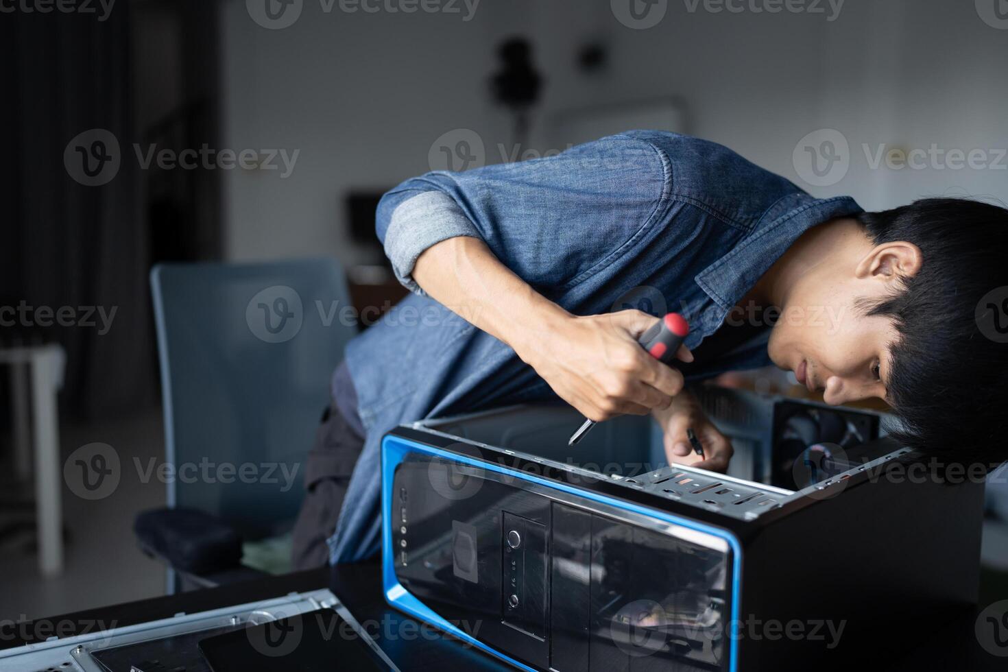 a man is working on a computer in a room. photo