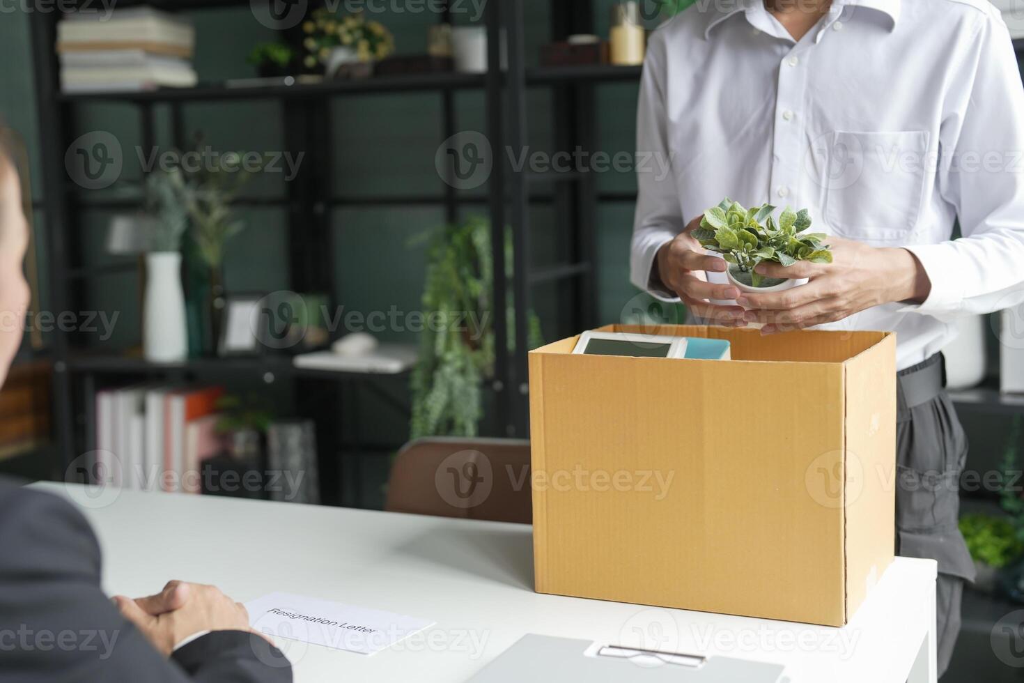 a man is holding a plant in a box. photo