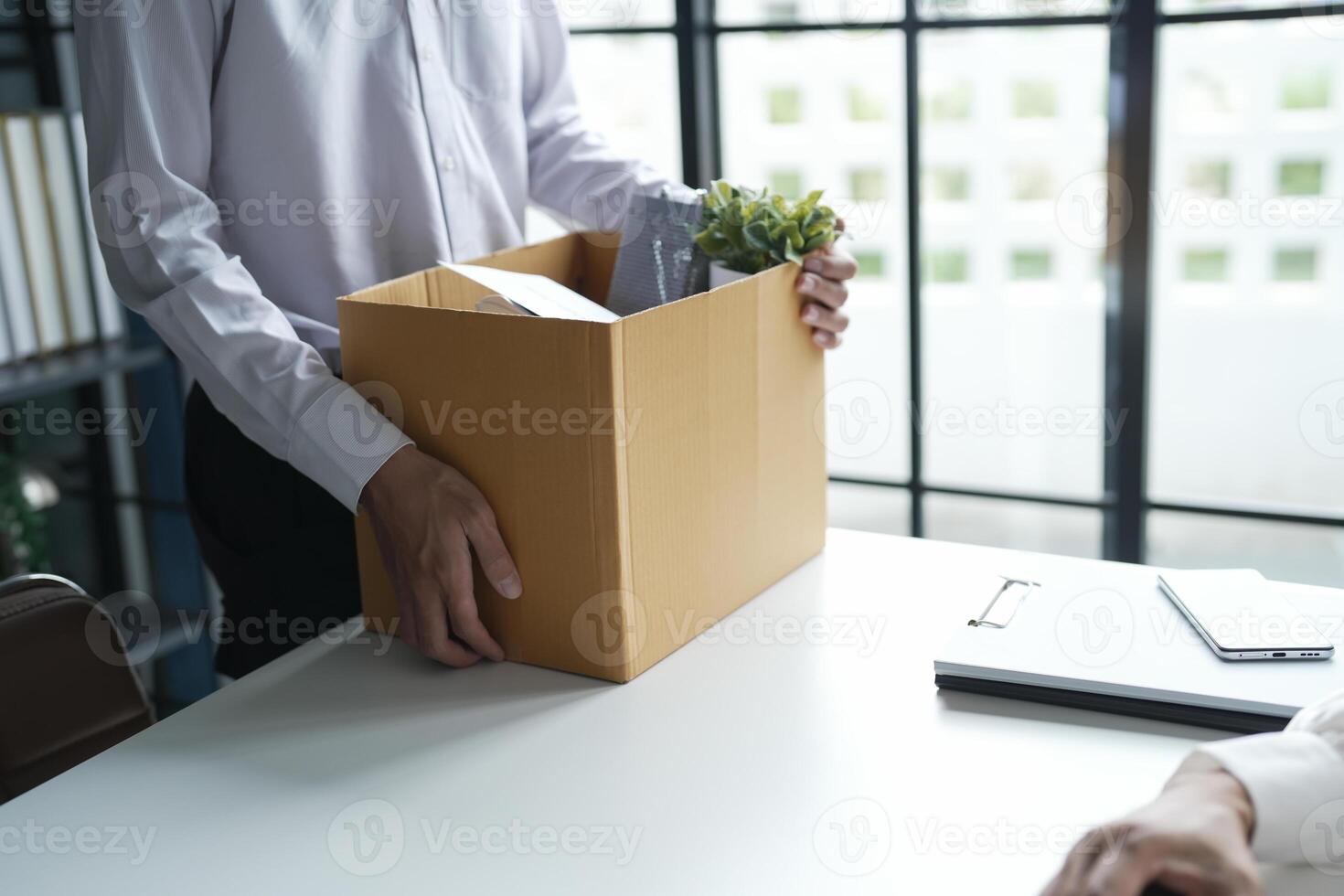 Business man sending resignation letter and packing Stuff Resign carrying business cardboard box Change of job or fired from company resign. photo