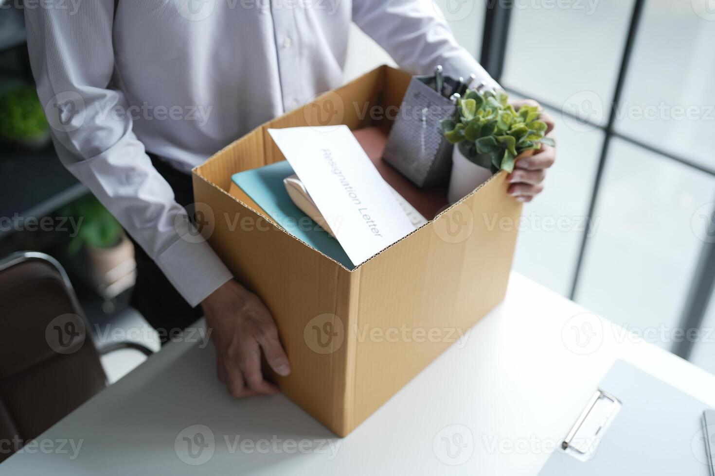 Business man sending resignation letter and packing Stuff Resign Depress or carrying business cardboard box Change of job or fired from company resign concept photo