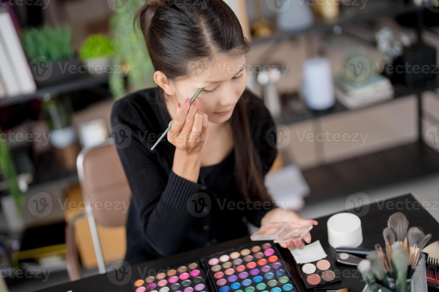 beauty Asian woman applying make up foundation and concealer make up on face with cosmetics makeover Daily routine at home. photo