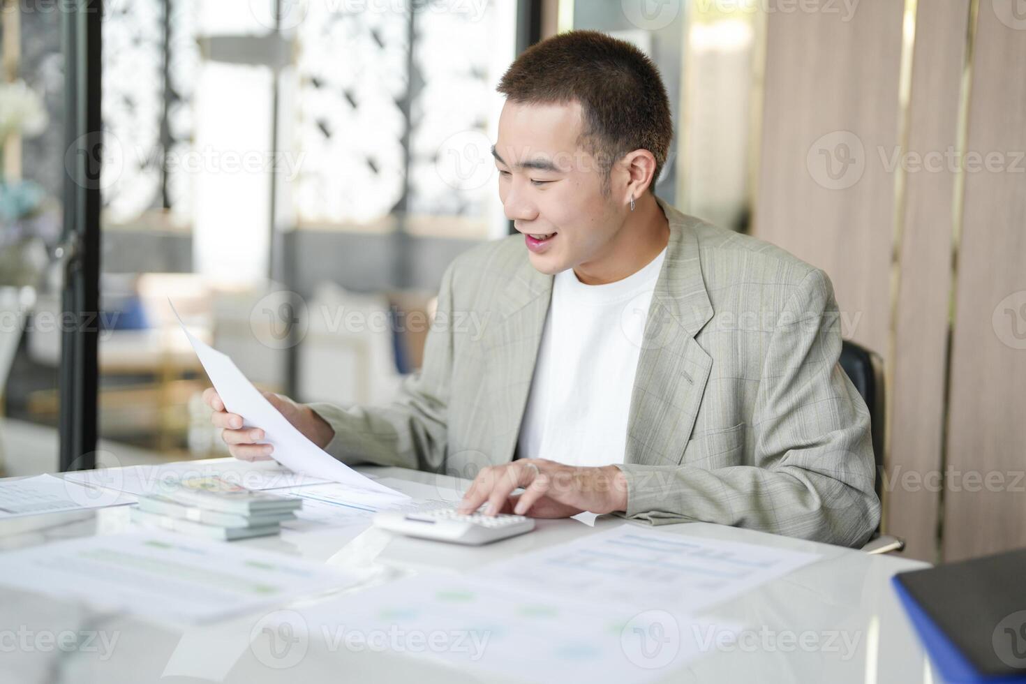 asian businessman working in office with papers and calculator photo
