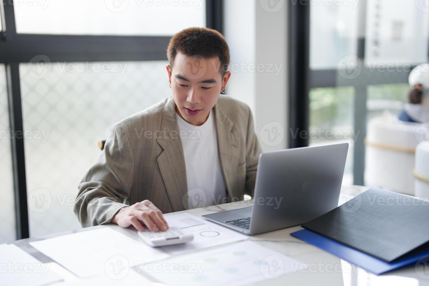 Attractive confident millennial Asian Business man using laptop computer and professional working investor start up project business planning in office photo