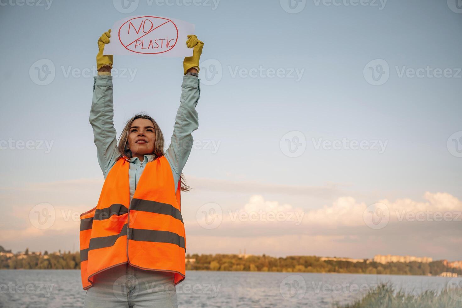 Hands,,, holding banner with 'no plastic', text on it. Woman volunteer is against trash pollution outdoors photo