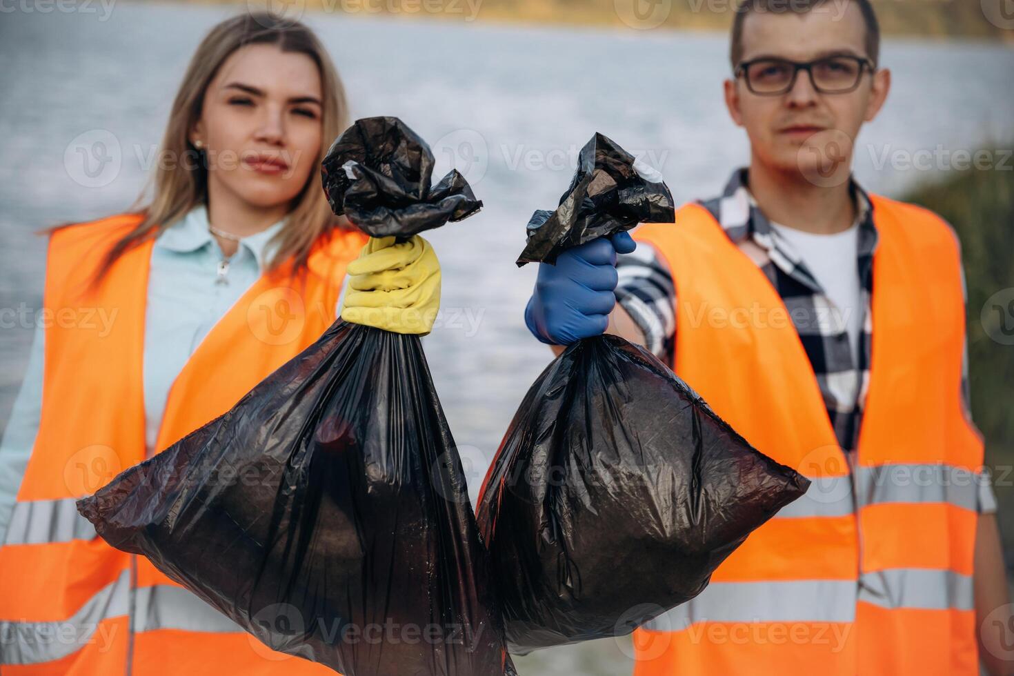 A volunteers collects garbage on a ,muddy beach photo