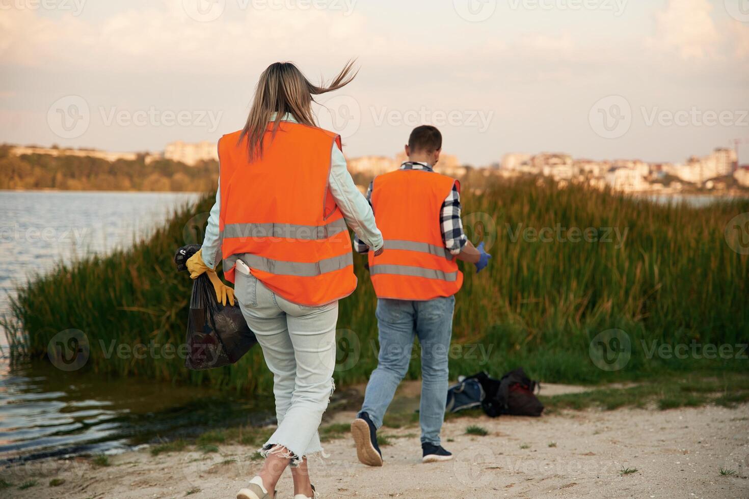 A, volunteers collects garbage on a muddy beach photo