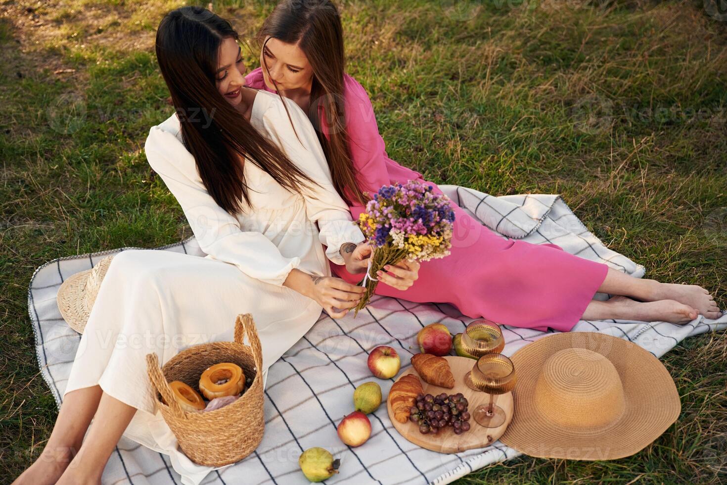 Fresh,,, fruits and flowers. Lesbian couple is together on the picnic in nature photo