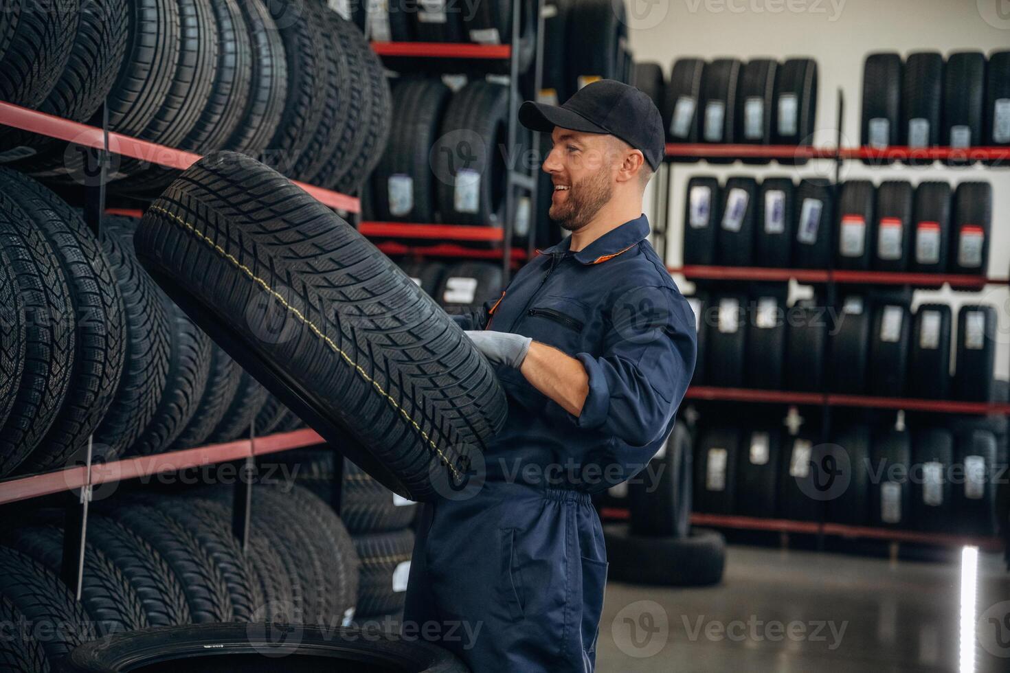 Holding the wheel., Man ,,,,worker is maintenance station with tires photo