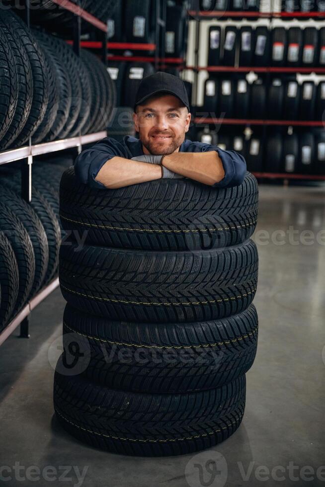 Inside ,of, the ,,wheels, having fun. Man worker is maintenance station with tires photo