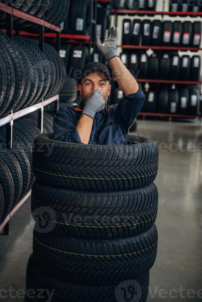Fun, pretending to dive inside the wheels. ..,Man worker is maintenance station with tires photo