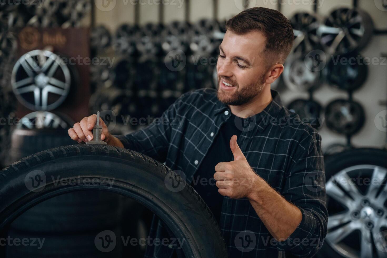 Ready for install, perfect measure,,,,, with tool. Man worker is maintenance station with tires, wheels photo