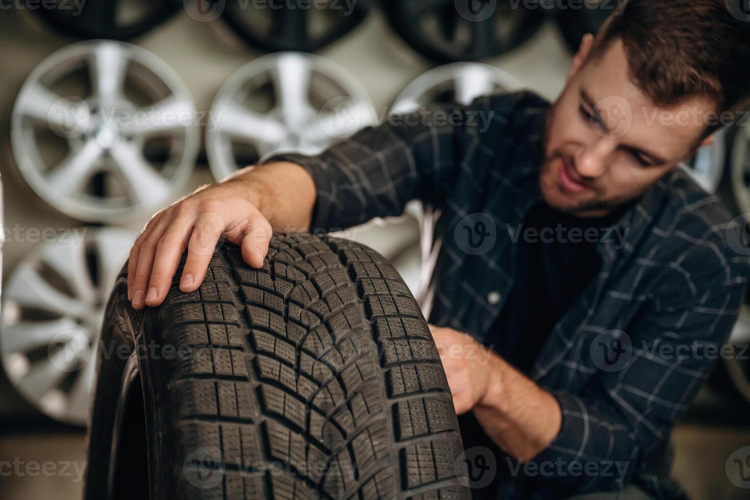 Sitting, professional man ,,worker is maintenance station with tires, wheels photo