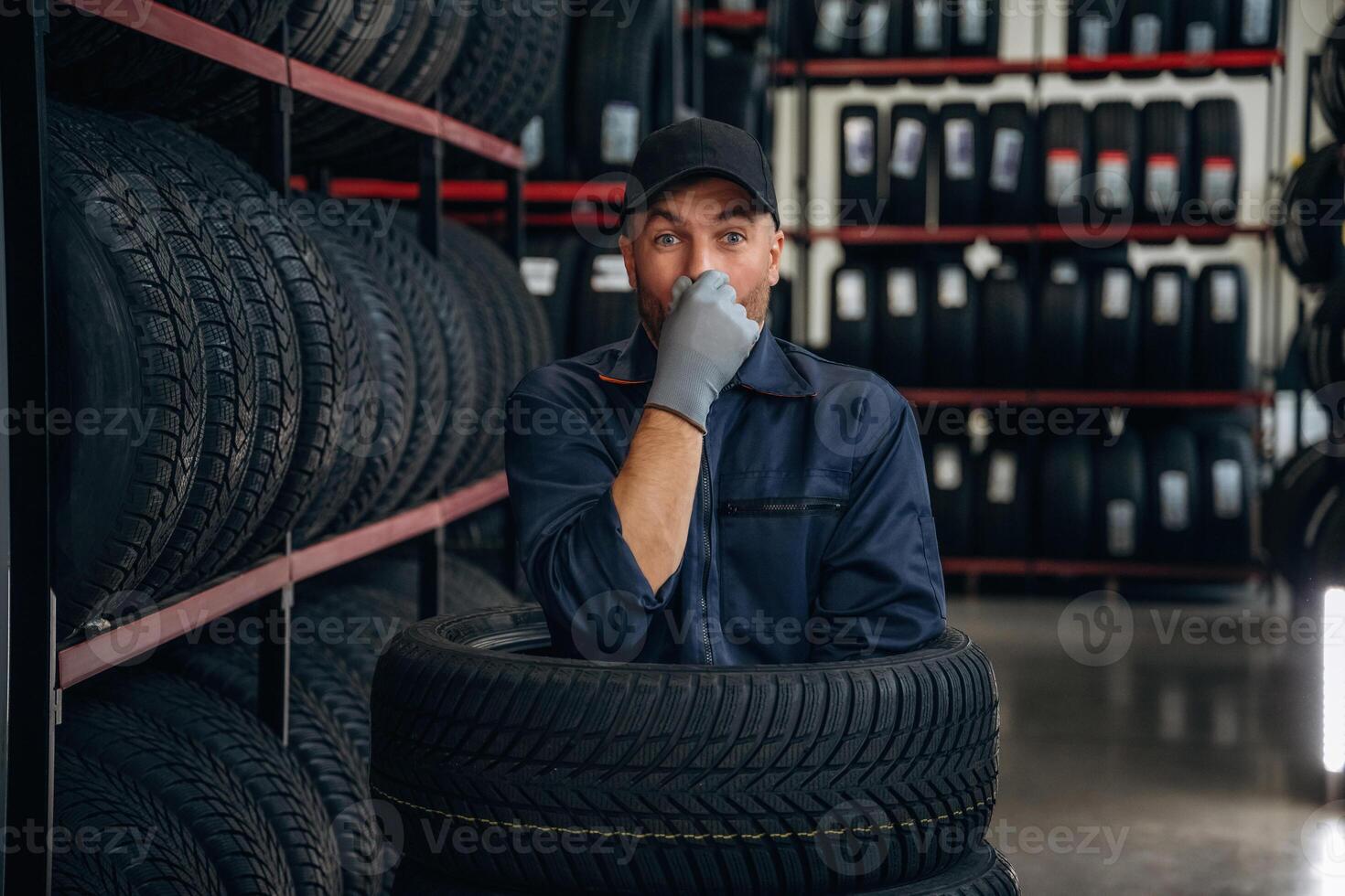 Fun,, pretending,, to dive inside the wheels. Man worker is maintenance station with tires photo