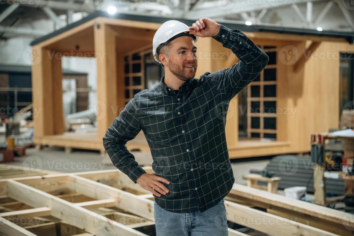 Looks, far,,, away. Male builder is at construction of wooden house photo