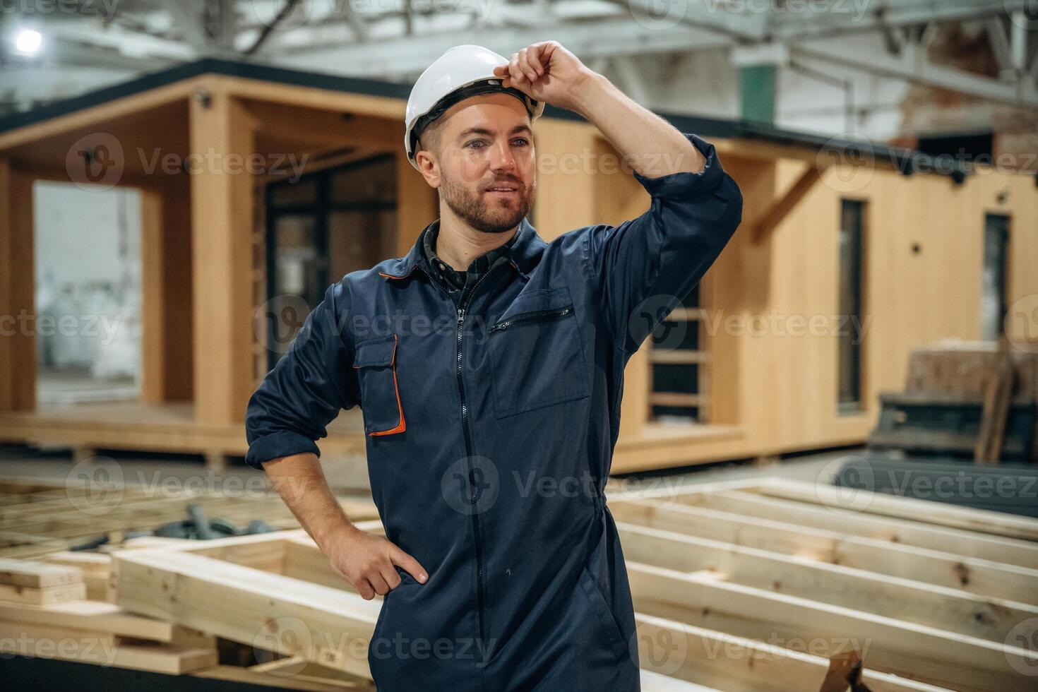 Looks, far, away. Male builder is at construction of wooden house photo