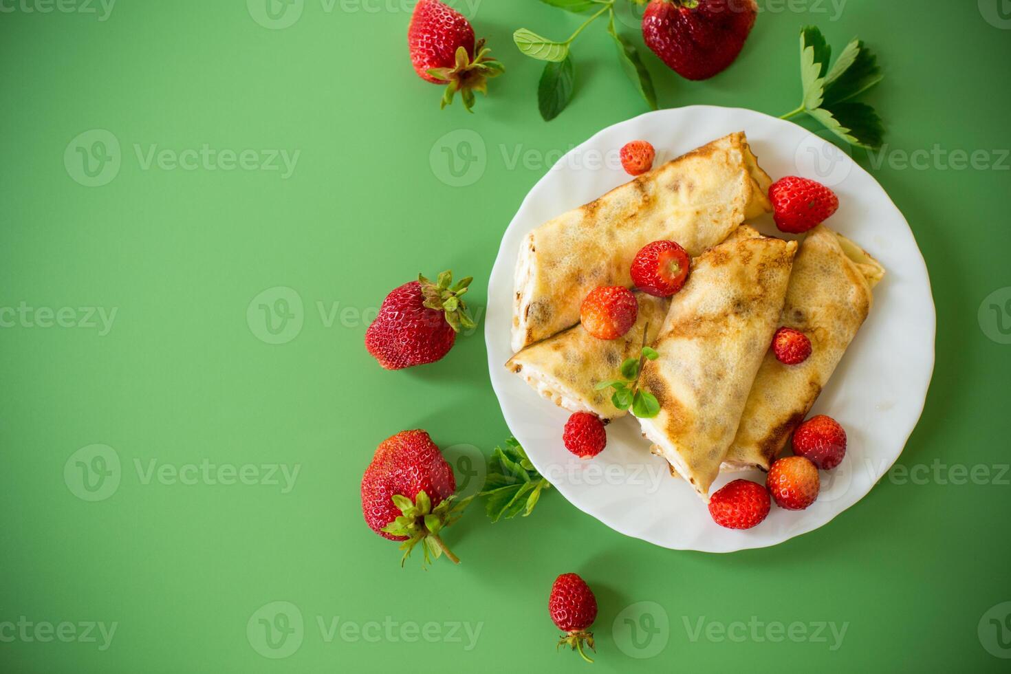 Appetizing pancakes with berries isolated on a green background . photo