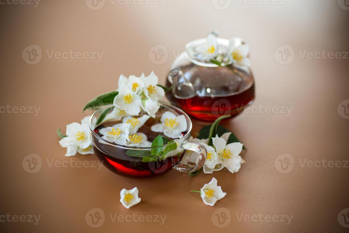 Natural green tea with jasmine petals on a brown background . photo