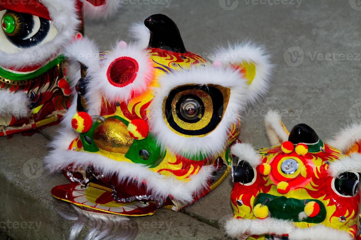 Three Chinese Lion Dancing Head Masks On Sidewalk photo