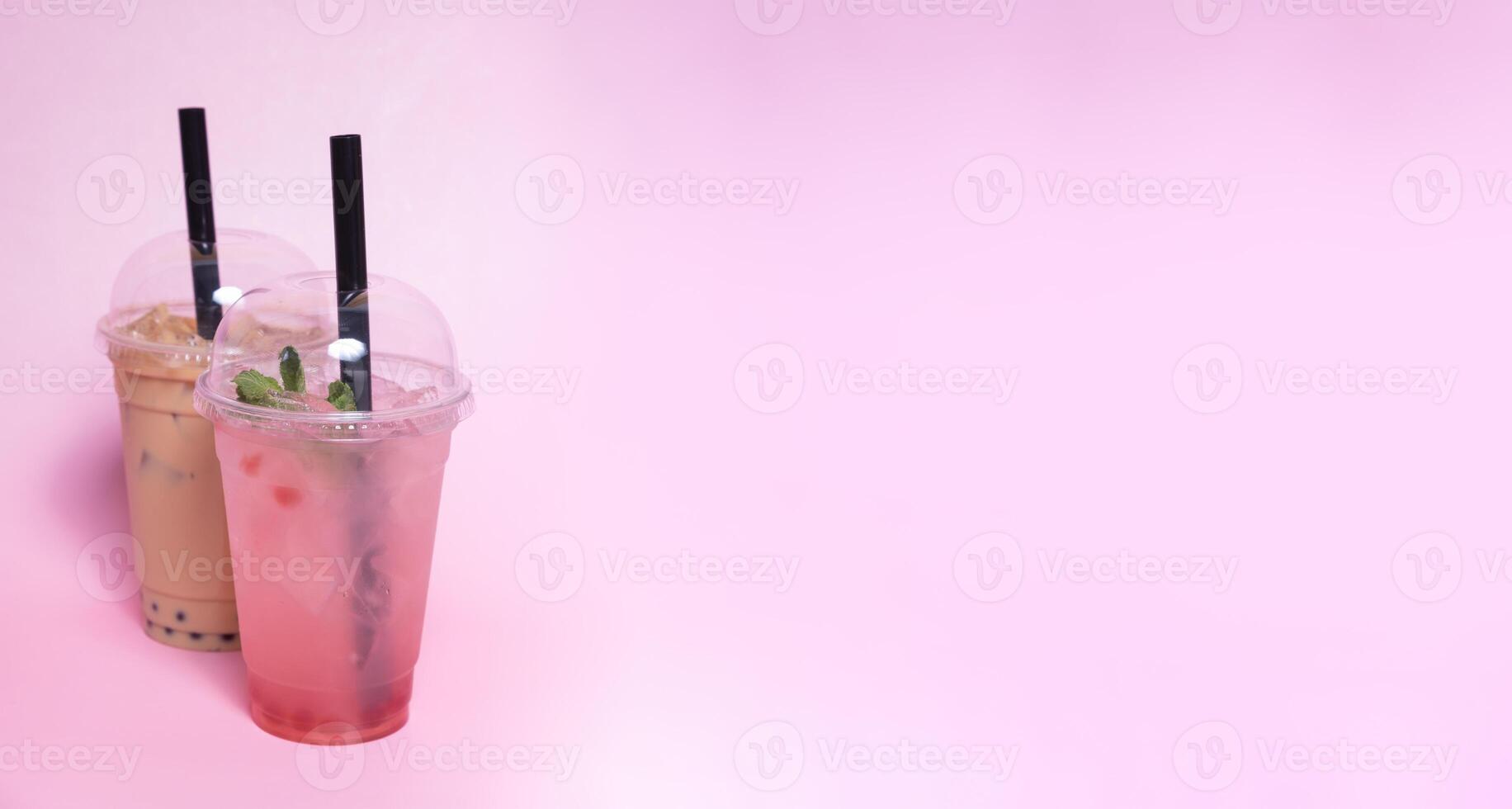 Two plastic glasses with bubble tea and ice with copy space photo