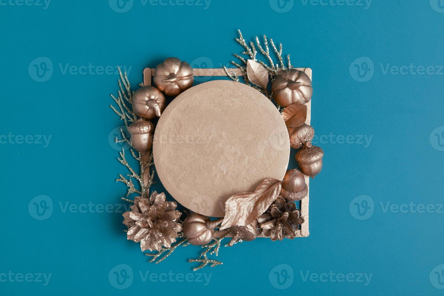 Still life of golden acorns, cones, leaves and pumpkins on a turquoise background with a pedestal photo