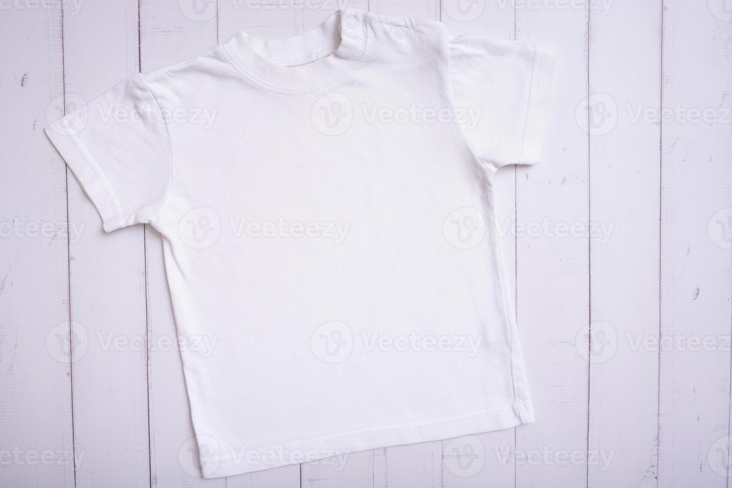 White children's t-shirt mockup for logo, text or design on wooden background top view photo