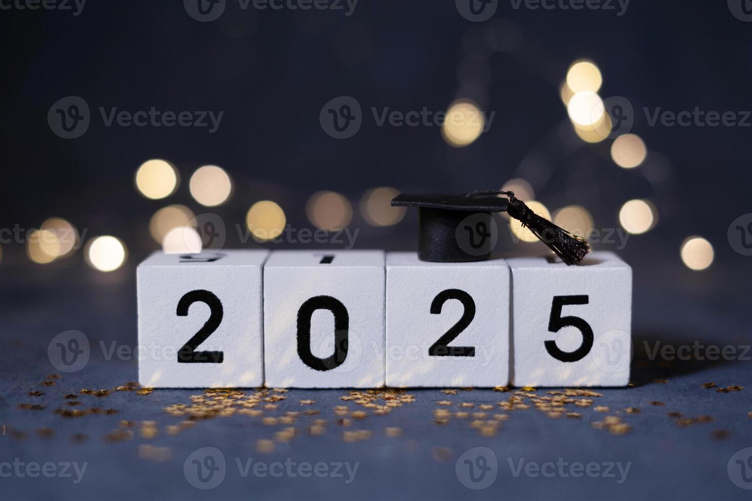 Class of 2025 concept. Wooden cubes 2025 with graduate hat on dark background with bokeh photo