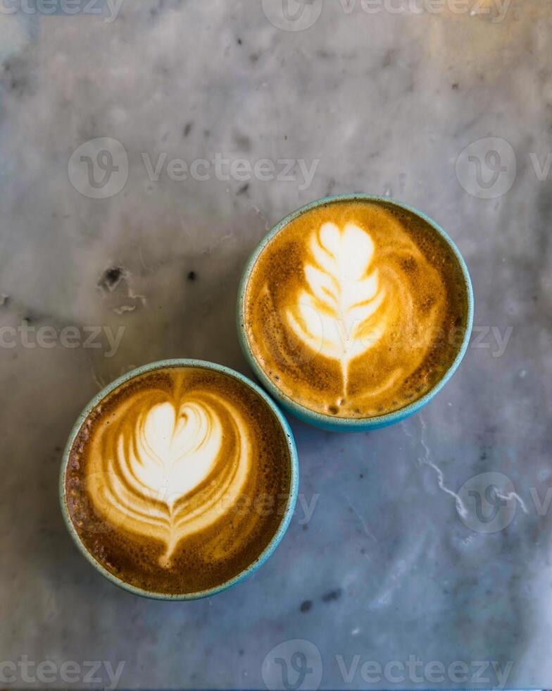 Two Latte Art Coffees On Marble Table photo