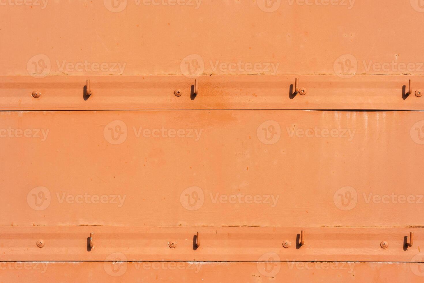Orange Metal Wall With Empty Hooks photo