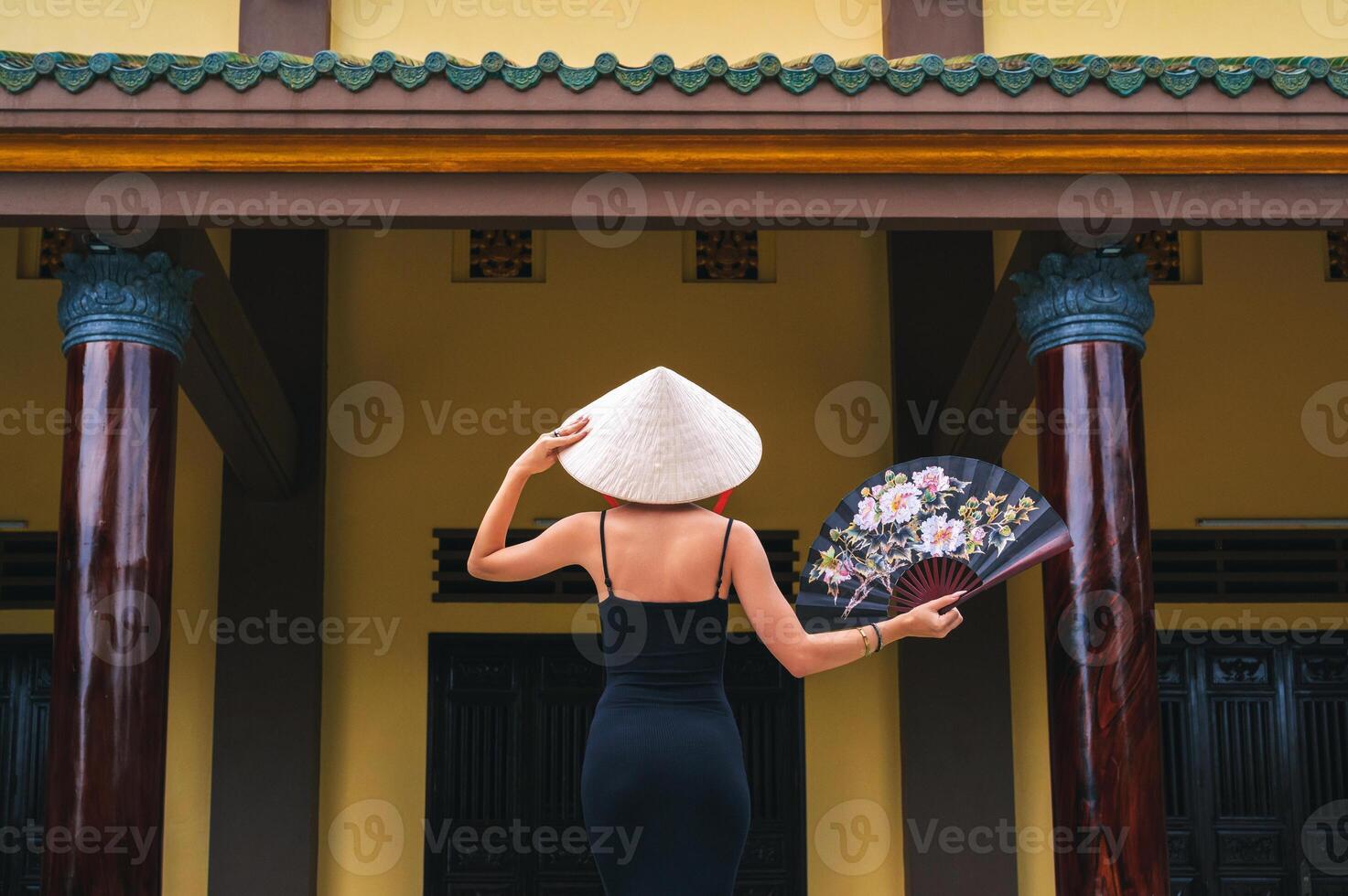 A tourist woman in a traditional Vietnamese Non La hat on the background of beautiful landscapes at the Linh Ung Son Tra pagoda in Da Nang photo