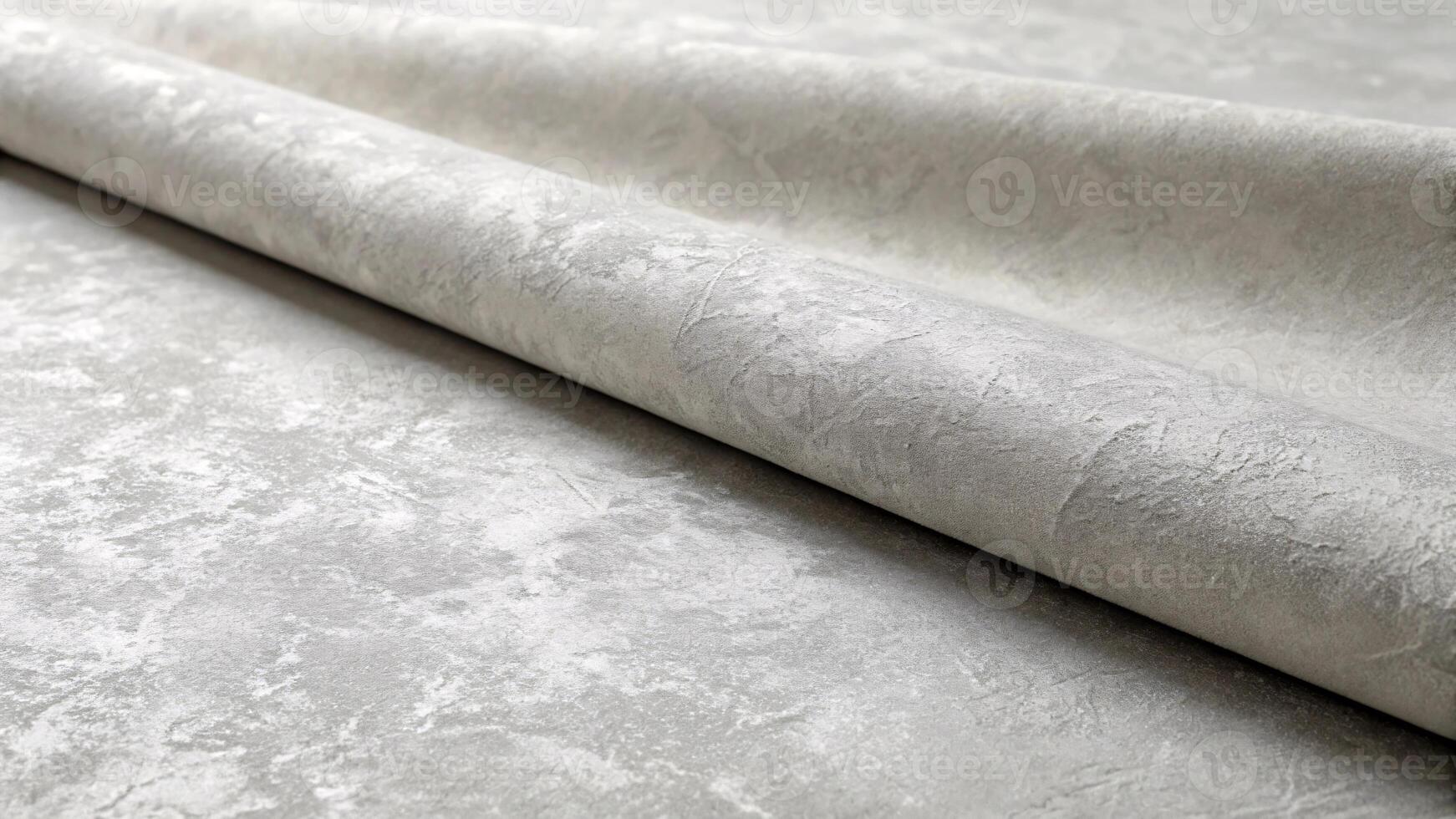 Rolls of gray fabric and a textured matte surface. photo