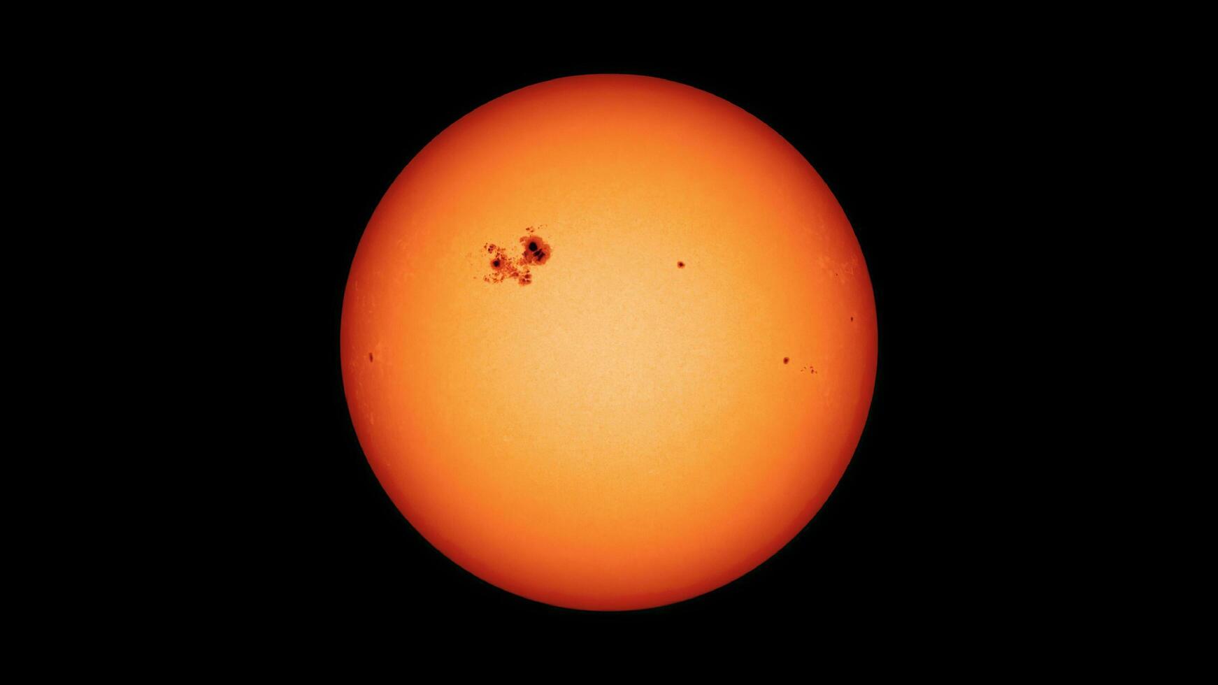 View of the sun with dark sunspots on surface. photo