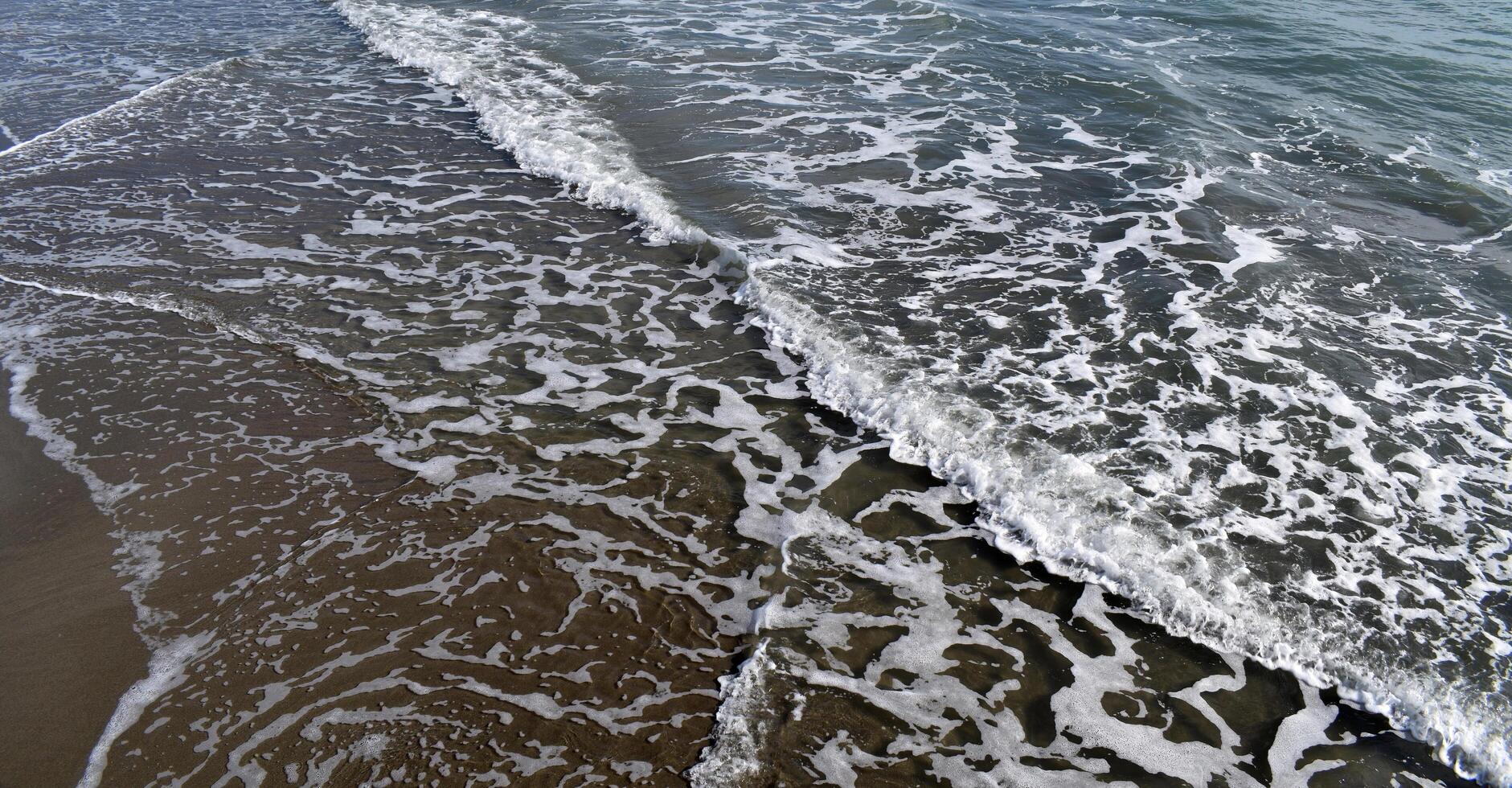Ocean waves gently lapping on the shore. photo