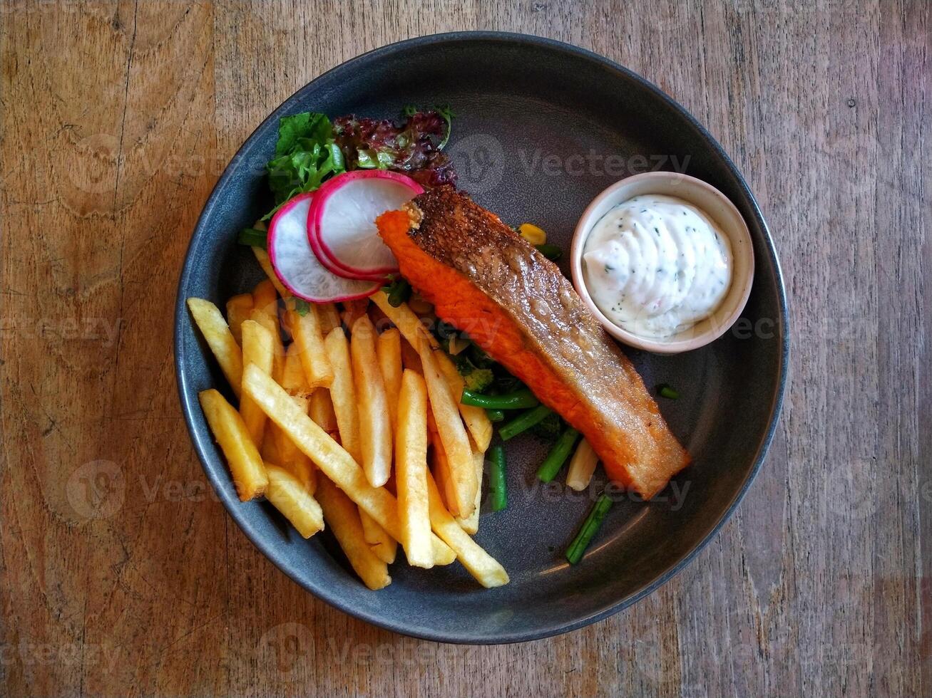 A plate with french fries and salmon photo
