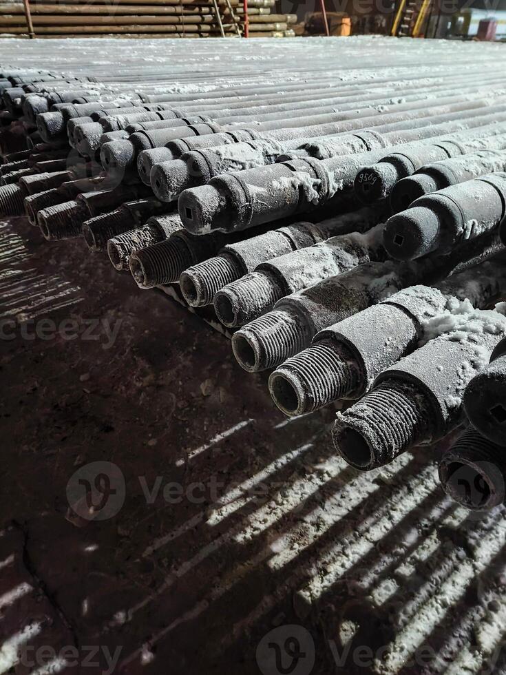 metal drill pipes with snow frost on the surface. Oil industry. Mobile photo