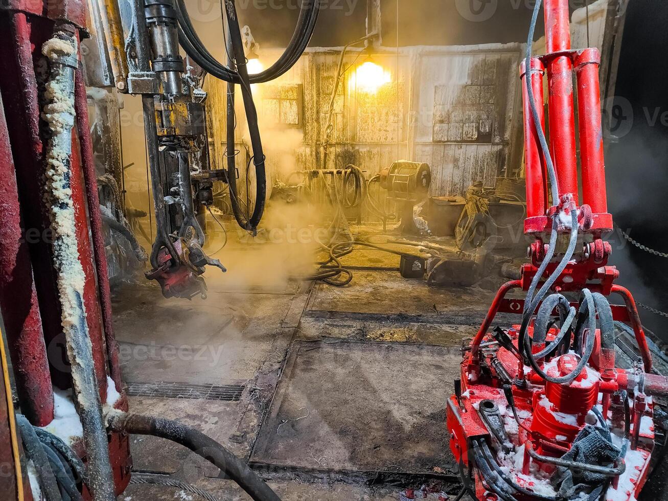 drilling rig interior with steam and red drilling tool. Oil industry. Mobile photo