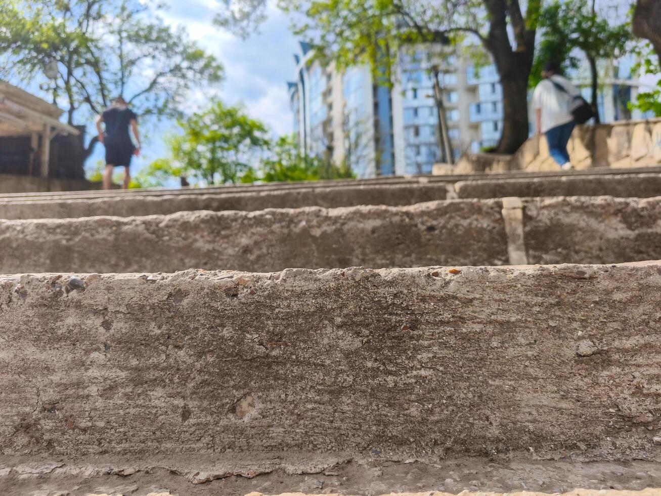 A close up of a concrete staircase with a person walking on it. The image has a mood of loneliness and solitude, as the person is walking alone on the steps photo