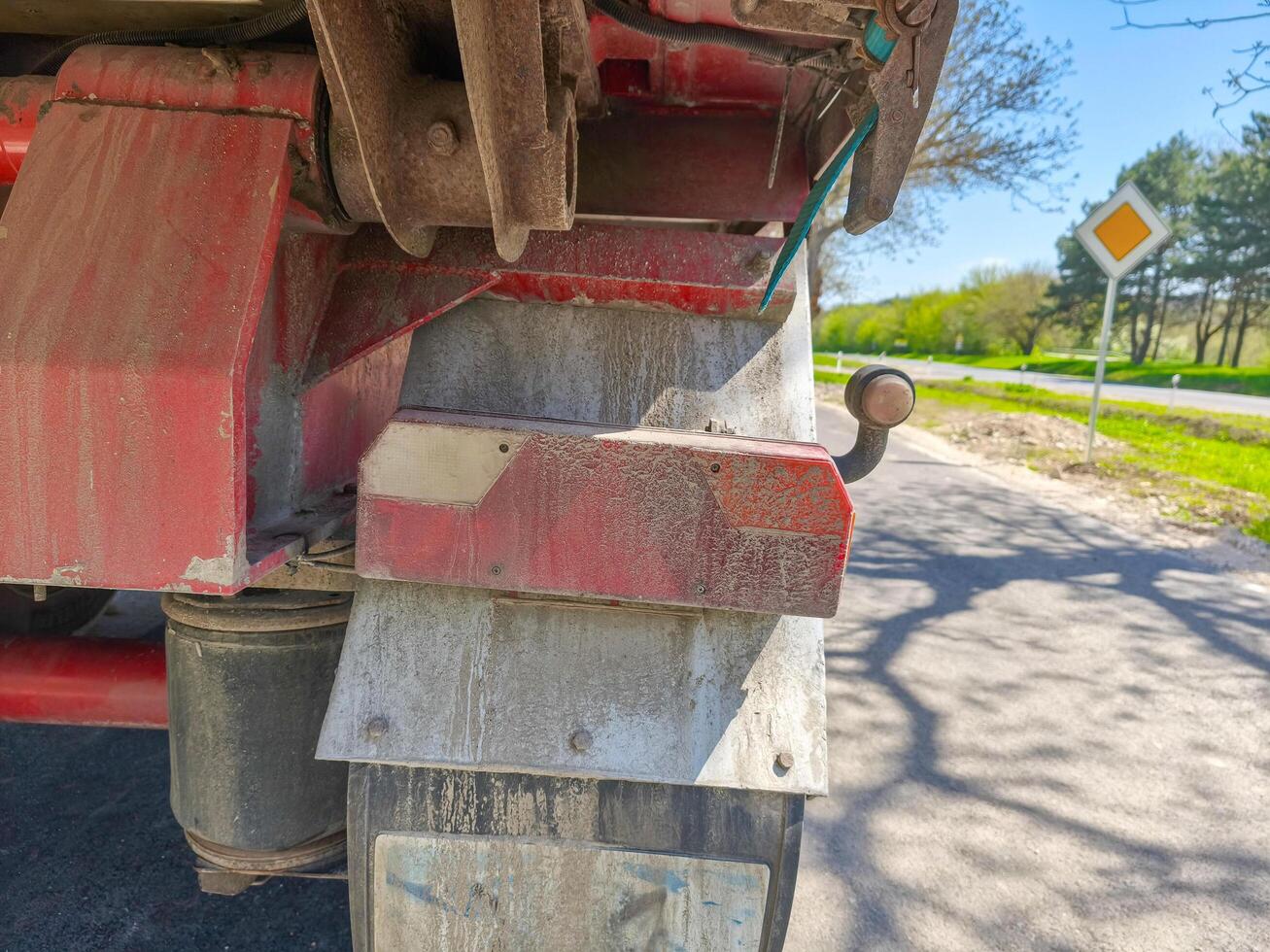 A dirty truck. The truck is parked on a road with a yellow sign in the background photo