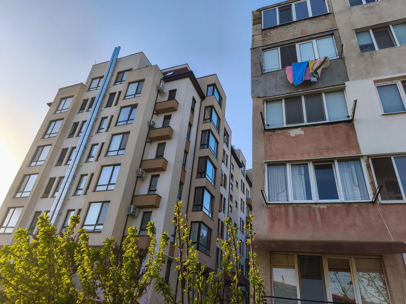 A building with a blue sign hanging from it. The building is tall and has many windows photo